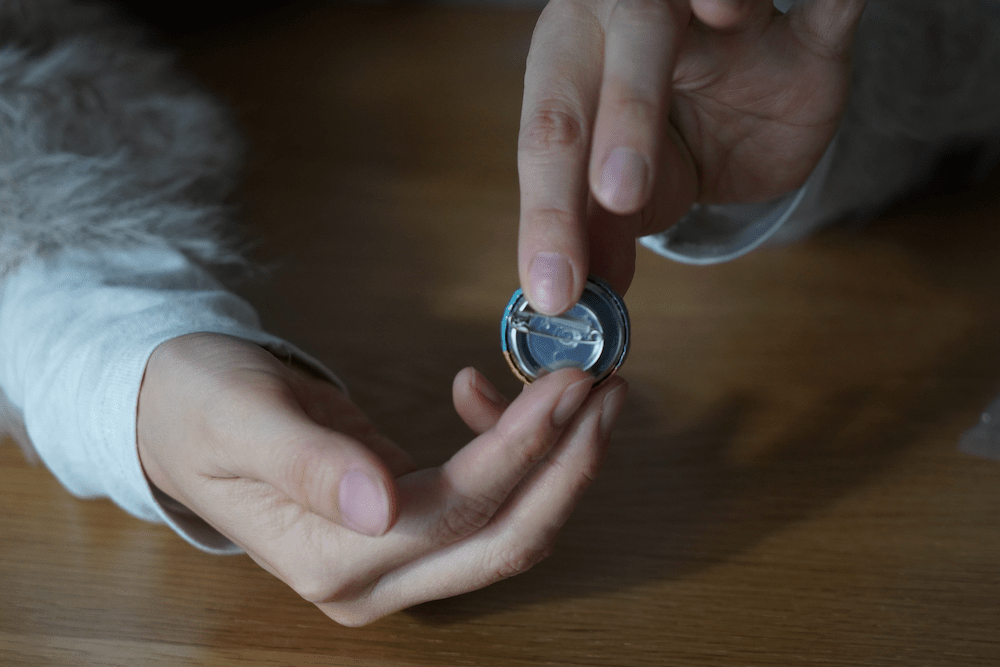 カンバッジグーで作った缶バッジにピンの部品をつけた写真